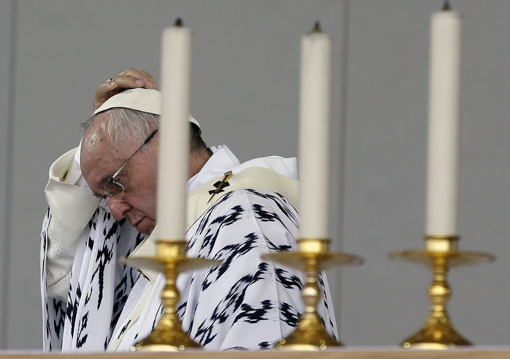 Pope Francis adjusts his skull cap as he celebrates Mass at Bicentennial Park in Quito, Ecuador, Tuesday, July 7, 2015. Pope Francis used his final Mass in Ecuador to issue an appeal for the missionary church that he has championed. (AP Photo/Gregorio Borgia)